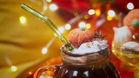 Close up of a Hot Cocoa topped with Whipped Cream in a Pumpkin-Shaped Mug in a Stock Footage 288595171