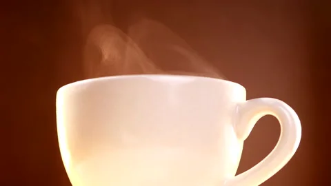 Close-up of hot coffee cup steaming on brown background Stock-Footage 139758960