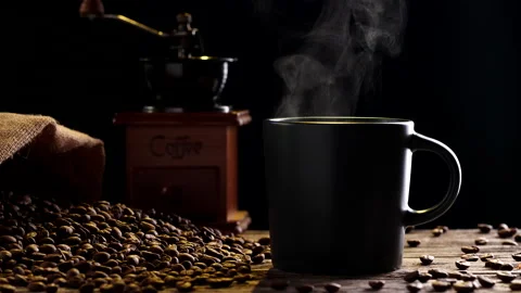 Close-up hot coffee cup with steaming smoke, coffee grinder, coffee beans Stock Footage 205086020