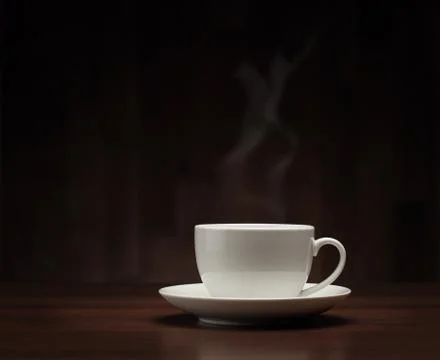 Close up of hot coffee cup on the table over dark background with copy space Stock Photos