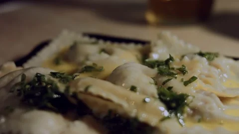 Close-up of hot cooked ravioli covered with melted butter and chopped parsley Stock Footage 144835082