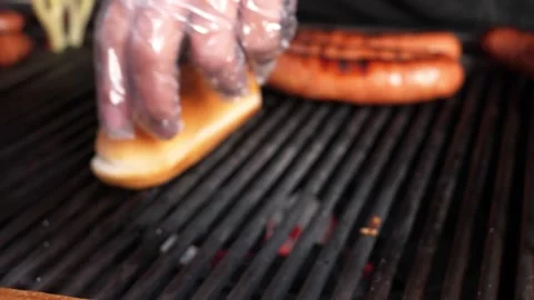 Close-up of Hot Dog Buns and Sausages Sizzling on a Professional Outdoor Grill Stock Footage 331955459
