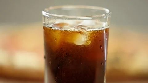 Close-up, hot fresh pepperoni pizza and a glass of cola with ice cubes. Stock Footage 246712340
