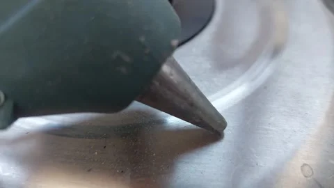Close up of hot glue gun nozzle on metal surface Stock Footage 334678440