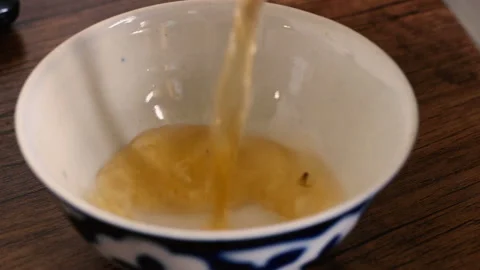 Close up of hot green tea pouring into asian uzbek national dish bowl Stock Footage