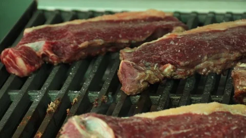 Close up of hot grill filled with steaks. Fire jumping on raw steaks on a gri Stock Footage 127715302