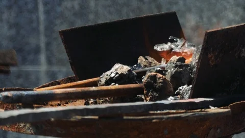 Close Up of Hot Metal Bar Being Heated in a Coal Forge in the Blacksmith Shop Video stock 110837100