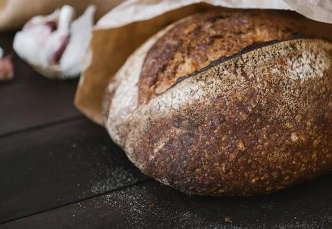 Close-up hot rye circle bread on a wooden table in craft package. Homemade Stock Photos
