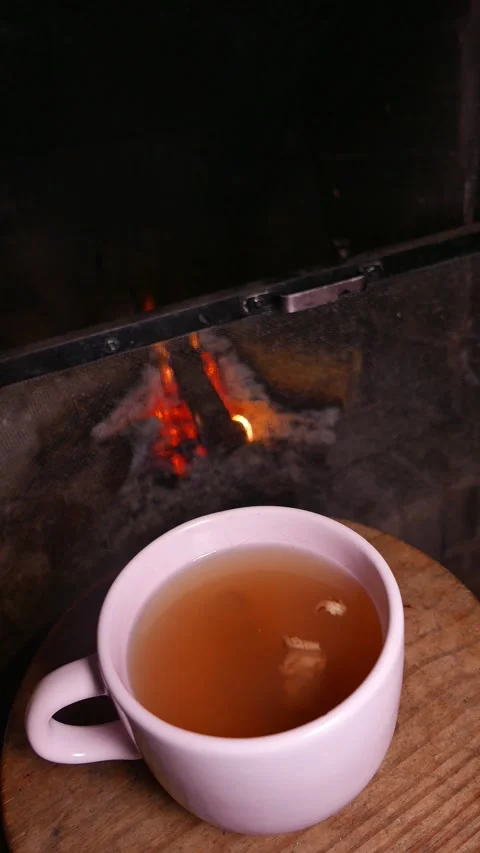 Close-up: hot teacup by the fireplace. Ginger tea with honey.  Tea table Stock Footage 344608021