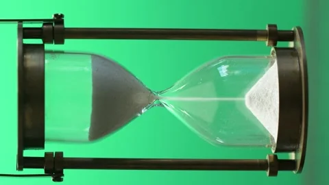 Close-up of hourglass measuring passing time with running sand on green screen Stock Footage 142116597