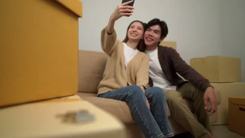 Close up of the house key on the boxes with background of happy couple taking se Stock-Footage 283829196