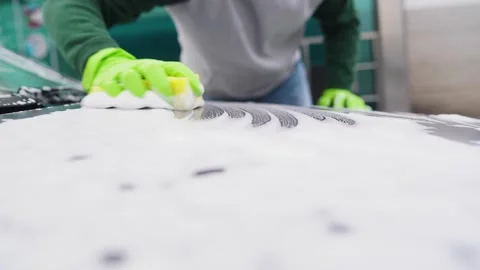 Close-up of how hands in gloves wash the hood of a car.car wash with foam Stock-Footage 164911539