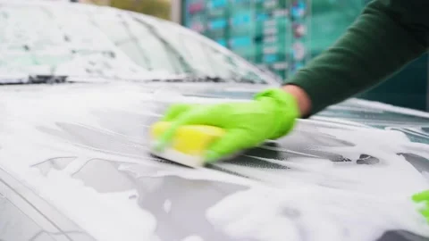 Close-up of how hands in gloves wash the hood of a car.car wash with foam Vidéo 164948967
