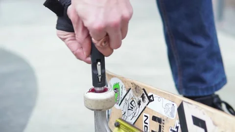 Close-up of how hands twists a colored wheel from a skate board in stickers Stock-Footage 165036352