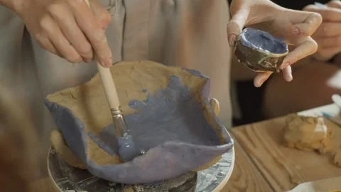 A close-up of how paint is applied with a brush to a clay product. Stock Footage 246492717
