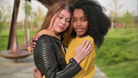 Close-up of hug of a young black and white woman. Beautiful and touching couple Stock Footage 141923547
