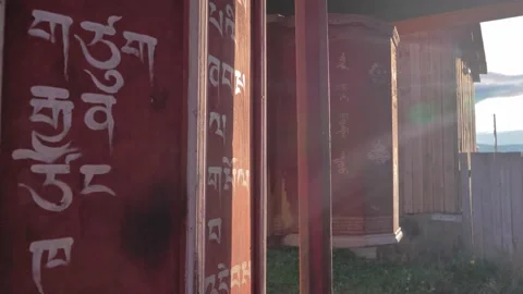 Close-up of huge aged Buddhist prayer wheels slowly spinning at sunset light Video stock 223366558