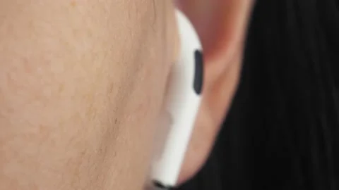Close-up human ear with a white wireless earphone. Stock Footage 220085399