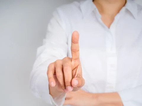 Close-up of a human finger pointing forward in a gesture of selection or to.. Stock Photos