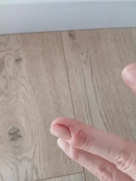 Close up of human fingers over light wooden laminate flooring background Stock Photos