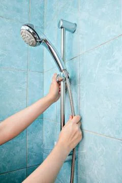 Close-up of human hand adjust the height holder shower head. Stock Photos