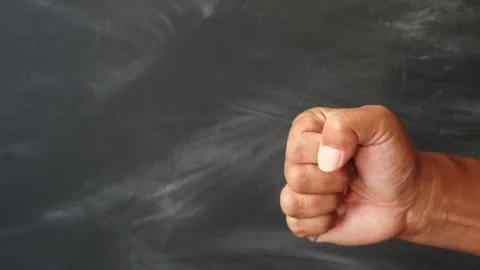 A close up of a human hand clenched into a tight fist against a dark background. Stock Footage 344796802