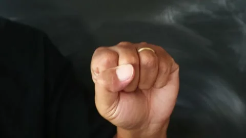 A close up of a human hand clenched into a tight fist against a dark background. Stock Footage 344796867