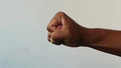 Close up of a human hand clenched into a tight fist isolated plain background Stock Footage 344797066