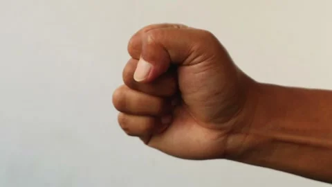 Close up of a human hand clenched into a tight fist isolated plain background Stock Footage 344797089