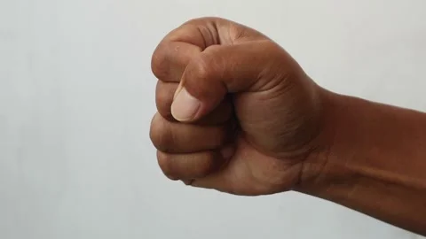 Close up of a human hand clenched into a tight fist isolated plain background Stock Footage 344797161