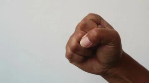 Close up of a human hand clenched into a tight fist isolated plain background Stock Footage 344797164