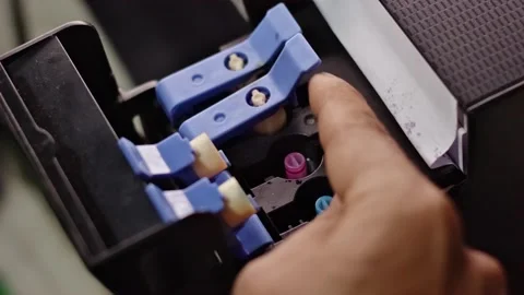 Close-up of a human hand closing and locking the ink tank cover on a printer 動画素材 338225947