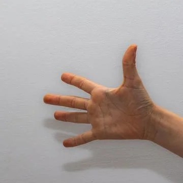 Close-up of a human hand fully extended with five fingers, set against a st.. Foto stock