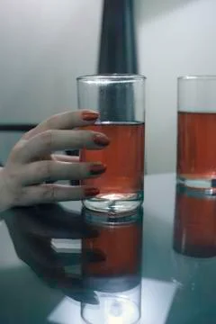 A close up a human hand holding a class on alcoholic beverage Stock Photos