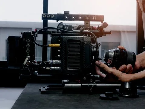 Close Up human hand inserting the cinema lens into a movie camera mount. Stock-Fotos