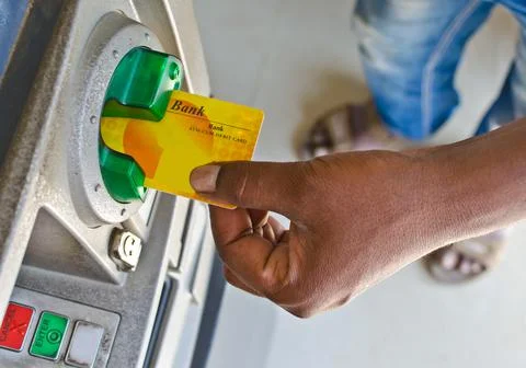 Close up of human hand inserting Credit/Debit card into ATM machine slot Stock Photos
