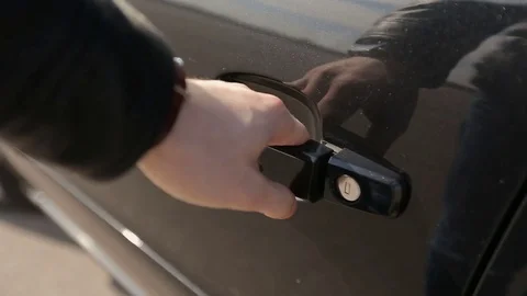 Close up human hand opening car door and getting into a car. Видео 73998478