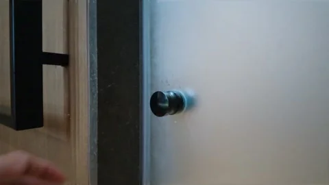 Close-up of a human hand reaching out towards a frosted glass door. Video stock 344091919