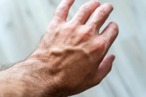 Close-up of a human hand reaching out with visible veins and skin texture, Stock Photos