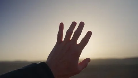 Close-up of a human hand reaching for the sunset Vídeo Stock 339074823