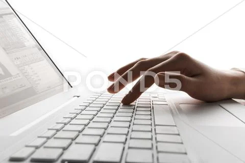 Close-up of human hand typing documents on keyboard of laptop Stock Photos