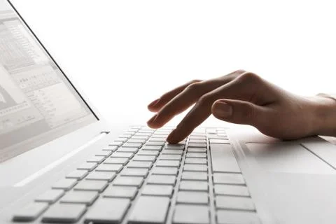 Close-up of human hand typing documents on keyboard of laptop Stock Photos