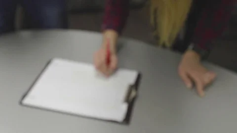 Close-up of a human hand writing something on the note paper on the table Stock Footage 74083152