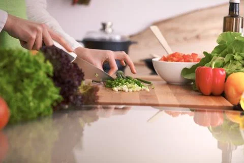Close Up of human hands cooking vegetable salad in kitchen on the glass table Stockfoto's