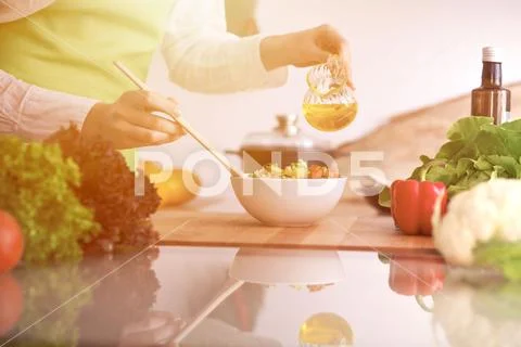 Close Up of human hands cooking vegetable salad in kitchen on the glass table Stock Photos