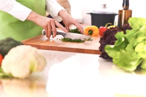 Close Up of human hands cooking vegetable salad in kitchen on the glass table Stock-Fotos
