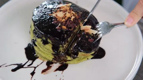 Close up of human hands cutting yummy healthy vegan pancakes with organic black Stock Footage 170474264