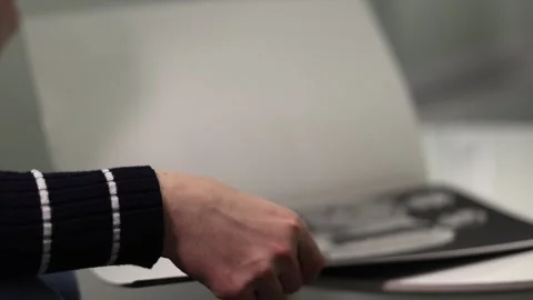 Close-up of human hands flipping through a magazine Stock Footage 321743924