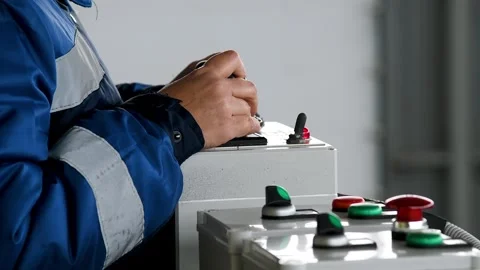 A close-up of human hands interacting with a control panel in a factory, wo.. Vidéo 331206161