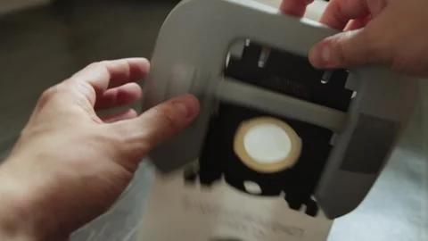 Close up of human hands replacing disposable dust bag of modern vacuum cleaner Stock Footage 336246871